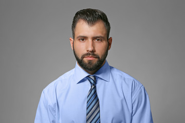Handsome man in formal clothes on grey background
