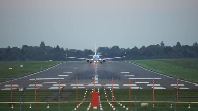 Passenger plane fly up over take-off runway from Hannover airport at sunset