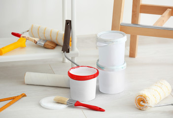 Decorator's tools and paint on floor indoors