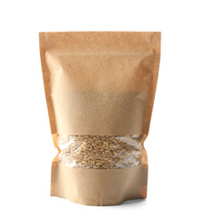 Paper package with wheat grass seeds on white background