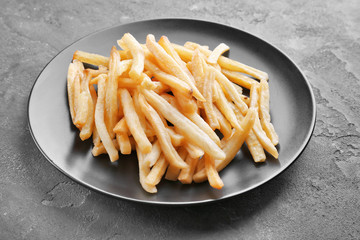 Plate with yummy french fries on kitchen table