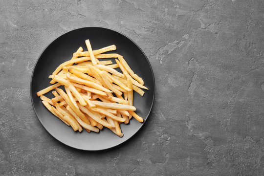 Plate with yummy french fries on kitchen table