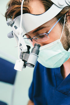 Dentist at work with magnifying glasses