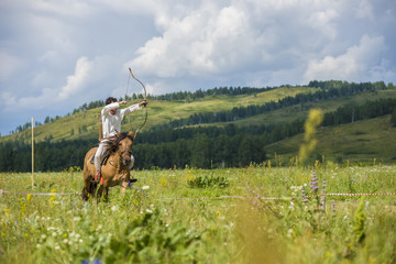 jockey, a rider on horseback jumps, dressed in an old folk costume of a nomad. archery on horseback