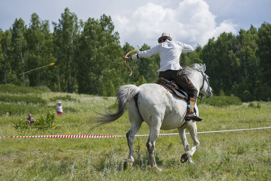 man hunter on a horse takes aim and shoot an archer. arrow flies in the air..