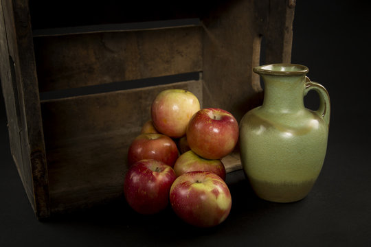 Apples and a Green Vase in an antique apple box and Black Background