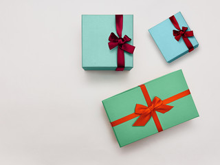 Gift box Trendy styled photo Three stylish multicolored gift boxes with bright ribbons on white background Top view Modern photo template with space for text