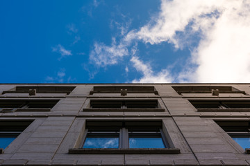 Fototapeta na wymiar Building Old Facade Looking Up Blue Sky Windows Office Building City Center