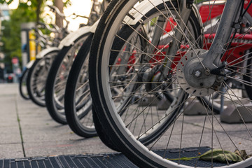 Fototapeta na wymiar Bike Wheels in Rack Closeup Detail Shot City Urban Environment Public Sharing Bicycle