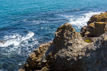 Fototapeta na wymiar Blue sea, waves and rocky shore.
