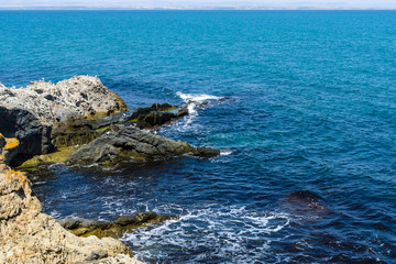 Blue sea, waves and rocky shore.