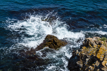Blue sea, waves and rocky shore.