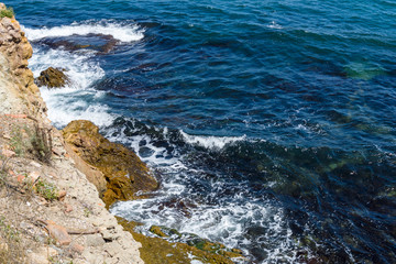 Blue sea, waves and rocky shore.