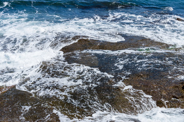 Blue sea, waves and rocky shore.