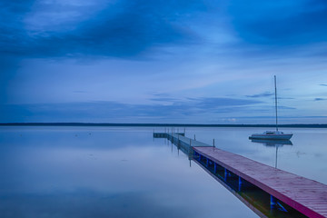Travel Concepts. Amazing Picturesque Braslav Lakes in Belarus. With Small sailing Boat on The Background. Taken During Blue Hour.
