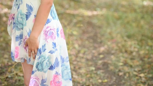 Woman wear flower dress standing in profile as the wind blow her dress