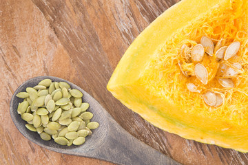 Roasted and salted pumpkin seeds on a rustic wooden counter