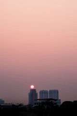 Fototapeta na wymiar Light of the morning sun behind the high-rise building
