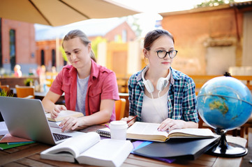 Smart young guy and girl doing their homework in University campus