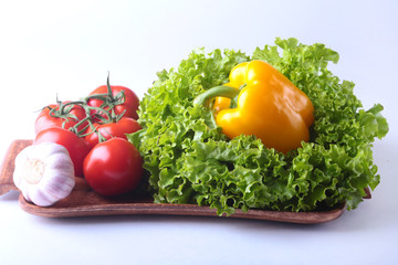 Fresh assorted vegetables bell pepper, tomato, garlic with leaf lettuce. Isolated on white background. Selective focus.