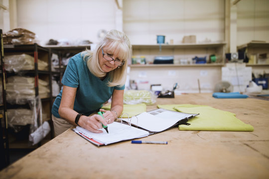 Businesswoman Doing Paperwork In Factory