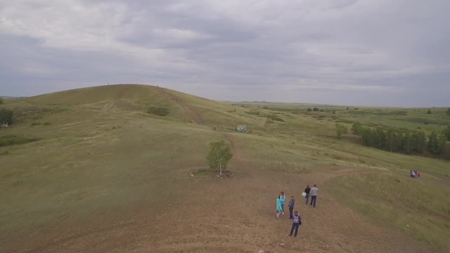 Arkaim in the Urals, aerial view. Spiral of stones on the top of the mountain, People attend a spiritual ritual organized around a spiral of stones