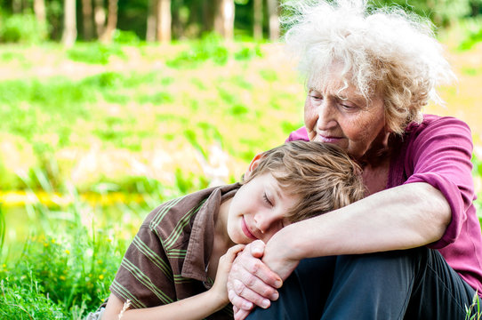 A grandmother with her grandson is resting in nature