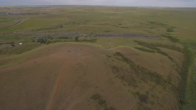 Arkaim in the Urals, aerial view. Spiral of stones on the top of the mountain, People attend a spiritual ritual organized around a spiral of stones
