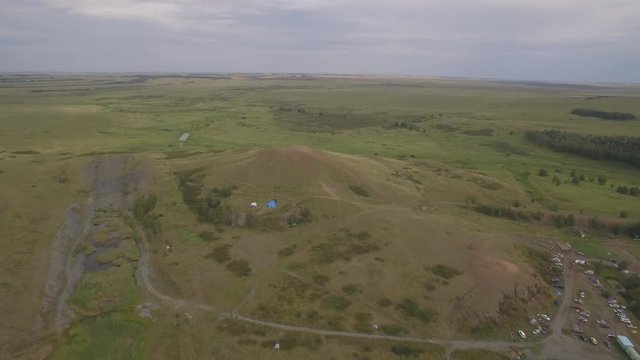 Arkaim in the Urals, aerial view. Spiral of stones on the top of the mountain, People attend a spiritual ritual organized around a spiral of stones