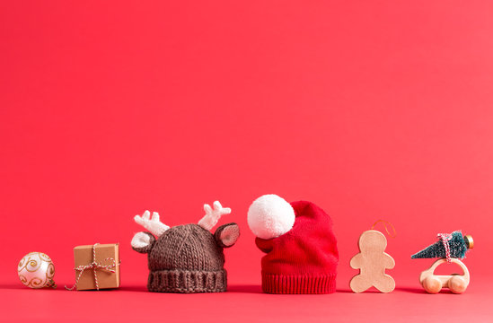 Knit winter hats with Christmas decorations on a red background