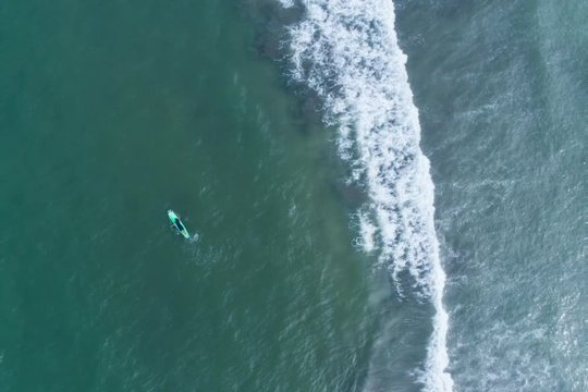 Surfboard on the sea shot from the sky
