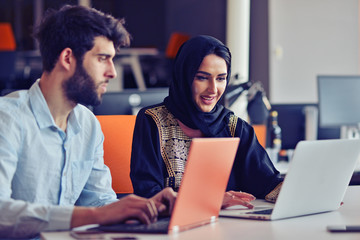 Multiracial contemporary business people working connected with technological devices like tablet and laptop