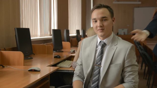 Young successful man gives the keys to the girl from the car, room, safe. Students in a computer class. Business man in suit gives secretary keys