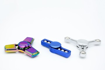 Three fidget spinners no brand common metal, white background, copy space. 