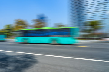 Blurred bus on the road with modern office building