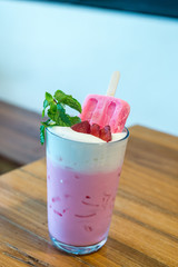 strawberry popsicle with pink milk in glass