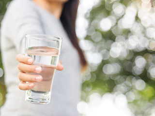 Closeup woman hand holding a glass of  water. Health care concept.