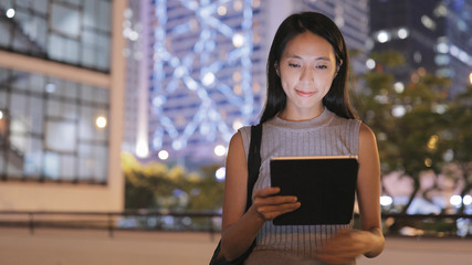 Young woman using digital tablet in Hong Kong at night