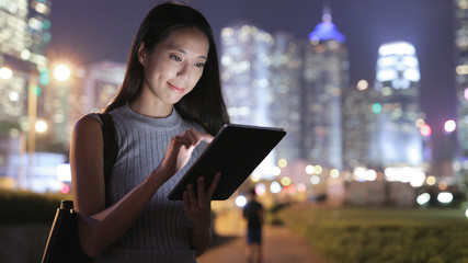 Woman using tablet computer at night