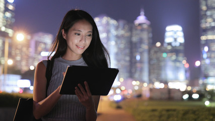 Woman looking at tablet computer in city