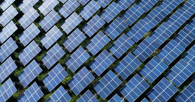 4K Aerial view of Solar Panels Farm (solar cell) with sunlight.Drone flight fly over solar panels field renewable green alternative energy concept in Thailand.