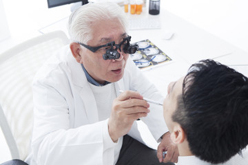 Veteran doctor inspecting oral cavity