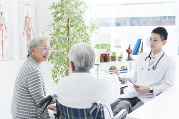 Fototapeta premium A young doctor and an elderly patient have a happy conversation