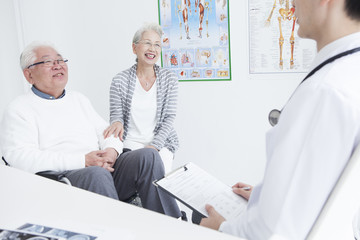 A young doctor and an elderly patient are talking