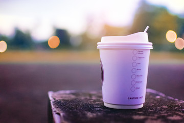 Hot Coffee take home on Brick platform with brokeh background.