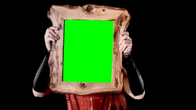 A sexy woman hiding behind a wooden frame with a green interior (use chroma key fx). 
