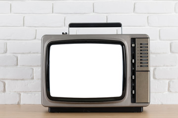 Old television with cut out screen on a white brick wall