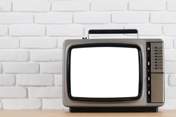 Old television with cut out screen on a white brick wall