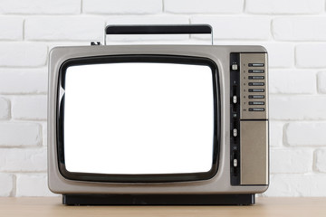 Old television with cut out screen on a white brick wall