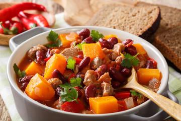 delicious pumpkin stewed with meat and vegetables close-up in a saucepan. horizontal